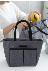 Gros plan d'un sac isotherme gris avec poignée portable et poche avant pratique