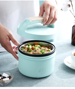 Detail view of light blue electric lunch box with 304 stainless steel interior and wood handle