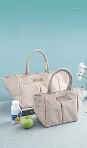 Close-up of portable insulated lunch bags with vertical texture and leather logo detail