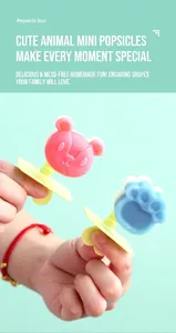 Detail showing cartoon bear and cat paw popsicle molds with yellow handles in a handheld view