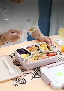 Detail view of four-compartment stainless steel lunch box with pink shell and utensils