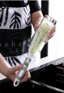 Detail of long-handle brush cleaning a glass cup with dense bristles and non-slip grip