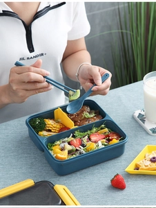 Detail showing partitioned blue bento box with yellow divider and matching cutlery set