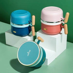 Close-up of portable stainless steel lunch boxes with wooden handles in three colors