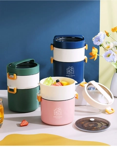 Macro detail of portable stackable lunch boxes in pink, green, and blue with handles