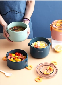 Detail van meerkleurige ronde lunchboxen met transparante deksels en gele gespen
