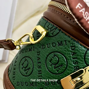 Detail of green bucket bag with textured logos and gold-plated hardware hooks