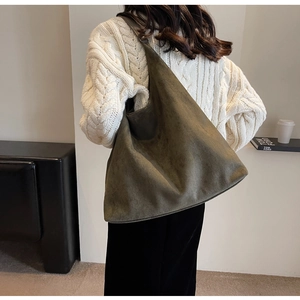 Detail shot of a large green suede hobo bag showing texture and oversized capacity