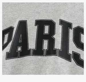 Gros plan d'un t-shirt en coton gris avec imprimé lettre Paris et texture du tissu