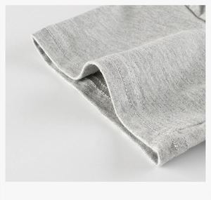 Vue détaillée de l'ourlet à double surpiqûre d'un t-shirt en coton gris pour enfants