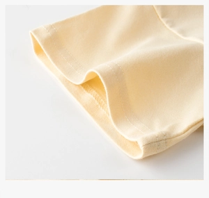 Detail of light yellow cotton T-shirt featuring double-needle stitching and soft knit fabric