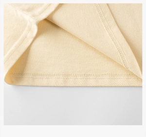 Detailed close-up of double-needle stitching on cream cotton t-shirt bottom hem