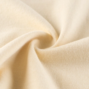 Close-up of premium cream-colored knitted fabric texture showing soft weave detail