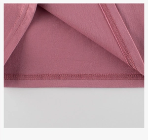 Detalle de la costura de doble aguja en el dobladillo de una camiseta rosa oscura