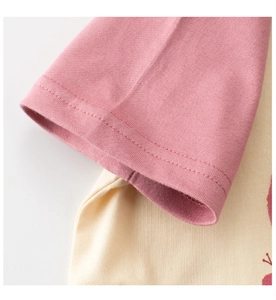 Détail des poignets roses et des coutures du t-shirt beige en coton pour enfant