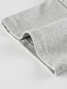 Gros plan d'un t-shirt en coton gris chiné montrant les détails de la double couture