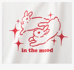 Close-up of white cotton T-shirt featuring a red running rabbits print and star details
