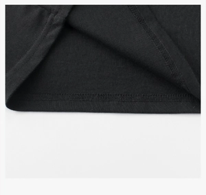 Close-up of double-stitch sewing detail and black cotton fabric texture on kids' t-shirt