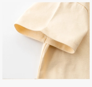 Gros plan sur la couture de manche et le tissu en coton doux du t-shirt jaune clair