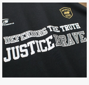 Detail of boys color-block cotton T-shirt featuring varsity style Justice Brave print