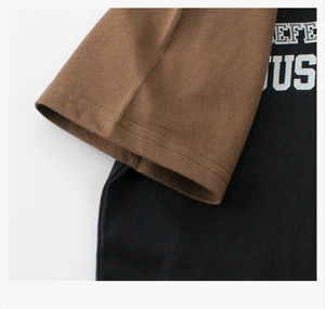 Close-up of color-block t-shirt showing brown sleeve stitching and black knit fabric