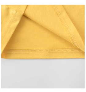 Detailed close-up of yellow cotton t-shirt hem showing high-quality stitching and fabric