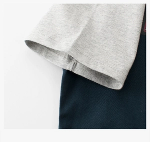 Vue macro des coutures de manches et double surpiqûre sur le t-shirt bicolore