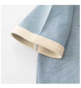 Detail of soft cotton knit sleeve with fine stitching on light blue kids t-shirt