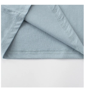 Detailed close-up of double-needle hem stitching on a light blue cotton kids' T-shirt