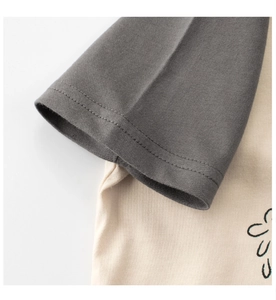 Detail of soft cotton knit fabric with contrast grey and cream patchwork and neat stitching