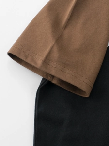 Close-up of color-block knit cotton T-shirt featuring brown and black panels and neat double stitching