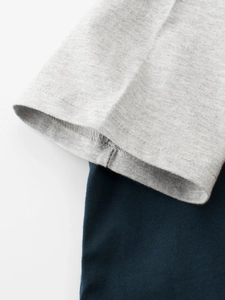 Gros plan détaillé des coutures et du tissu de qualité supérieure du t-shirt gris et bleu
