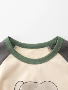 Girls' raglan sleeve cotton T-shirt featuring a green ribbed crew neck and cartoon print