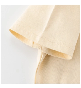 Detail view of cotton sleeve stitching and soft fabric texture on yellow kids t-shirt