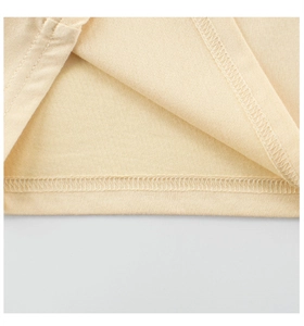 Detailaufnahme von Doppelnaht-Saum und Overlock-Stichen am beigen Baumwoll-Mädchen-Shirt