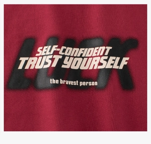 Dettaglio della trama del tessuto e stampa di lettere motivanti su t-shirt bordeaux