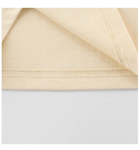 Detailed macro view of beige cotton shirt hem showing durable double-needle stitching