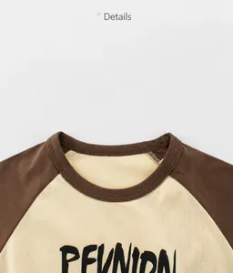 Détail de l'encolure en coton avec coutures précises et manches raglan contrastées
