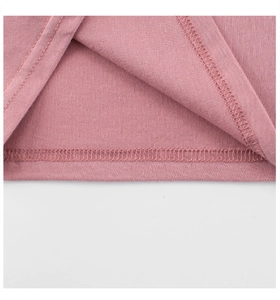 Macro detail of dusty pink knit fabric showing neat double-needle stitching on the hem