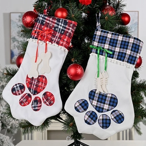 Detail of plaid pet Christmas stockings with wooden bone and fish bone tags on tree