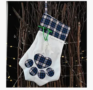 Close-up of paw-shaped plaid Christmas stocking with fishbone charms and a green bow