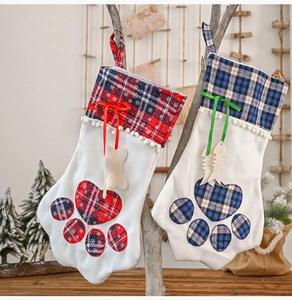 Detail of red and blue plaid pet Christmas stockings with paw embroidery and bone charms