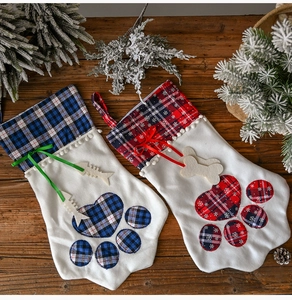 Close-up of paw-shaped Christmas stockings with plaid patterns and hanging bone charms