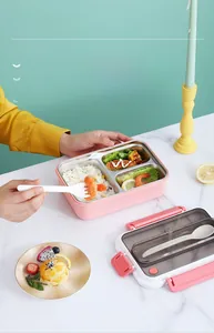 Three-compartment stainless steel bento box with pink outer shell and matching spoon