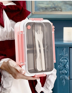 Close-up of divided bento box lid with integrated fork and spoon utensils