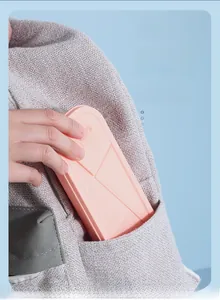 Portable pink cutlery box with geometric design shown fitting easily into a pocket