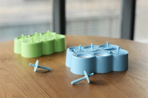 Detalle de moldes de silicona para polos de 6 cavidades en azul y verde sobre madera