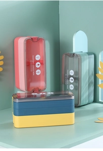 Gros plan d'une boîte à lunch bento empilable à trois couches avec des couvercles colorés
