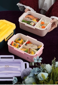 Vista detallada de una caja bento de tres compartimentos con porta cubiertos