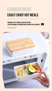 Dual-layer lunch box with bamboo lid showing bento compartments and food styling